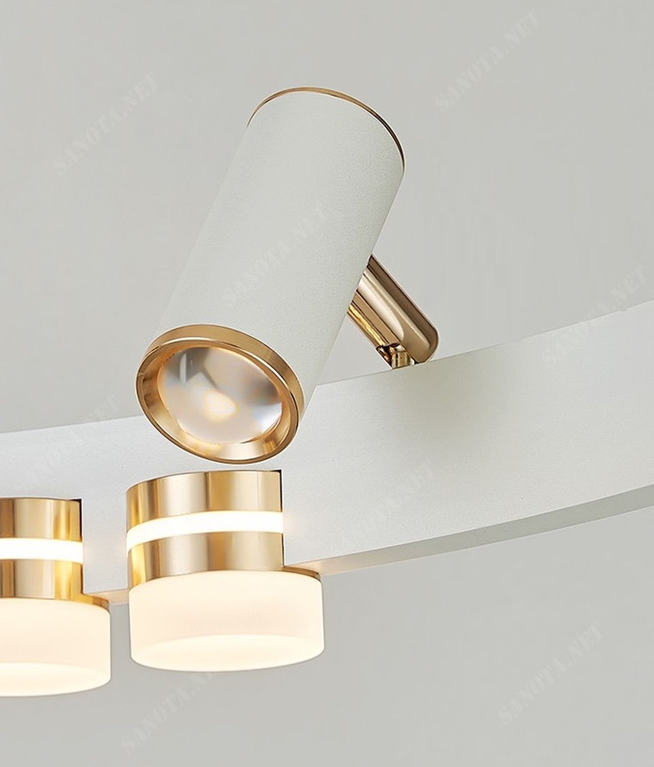 chiếc đèn ốp trần với thiết kế là một vòng tròn bị khuyết màu trắng cùng với đó là những bóng đèn led kết hợp với đèn rọi tạo nên một bức tranh ánh sáng nổi bật cả một không gian