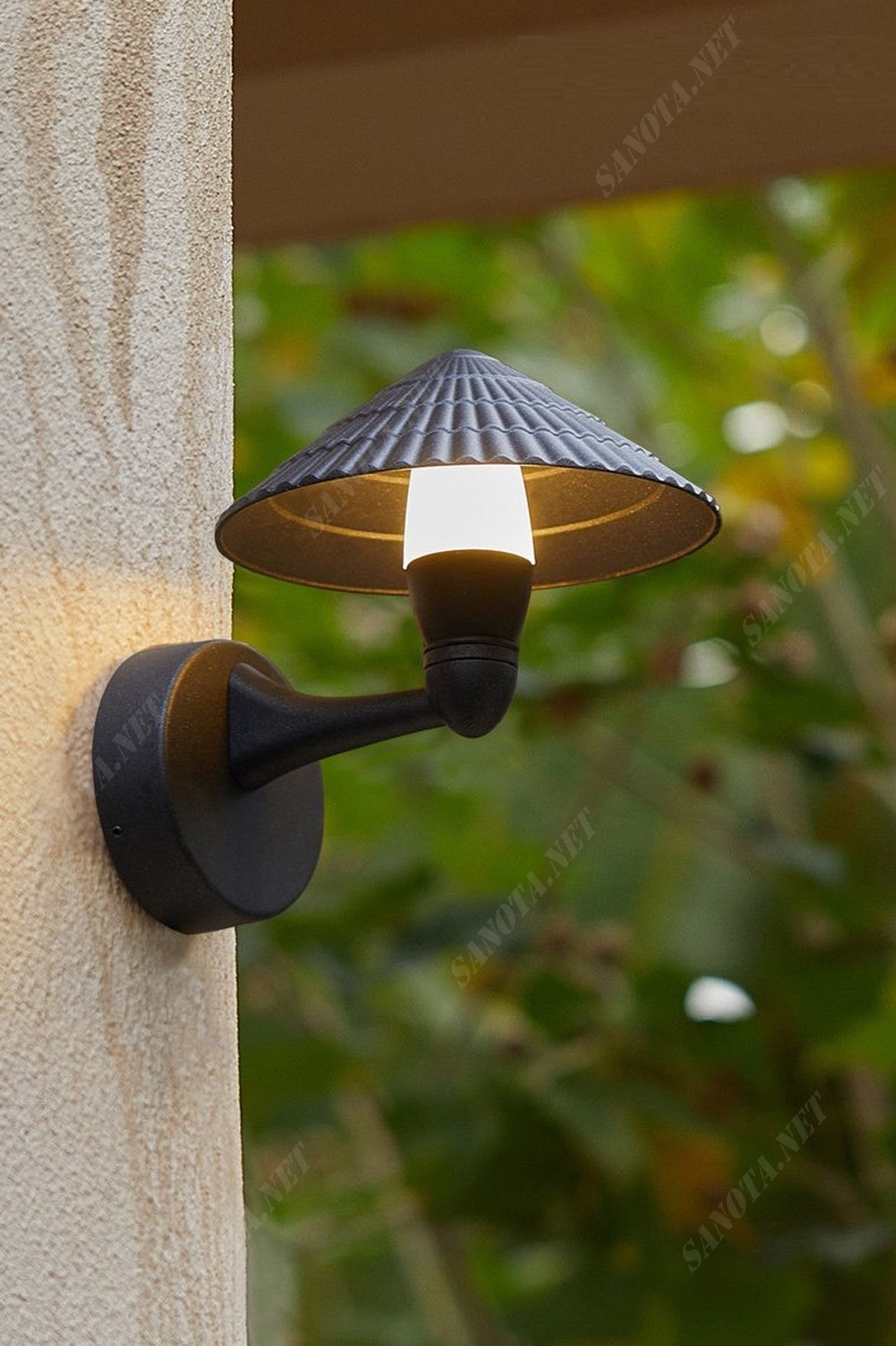 một chiếc đèn gắn tường mang phong cách cổ điển pha chút nét hiện đại với kiểu dáng chao đèn là một chiếc nón hình chóp