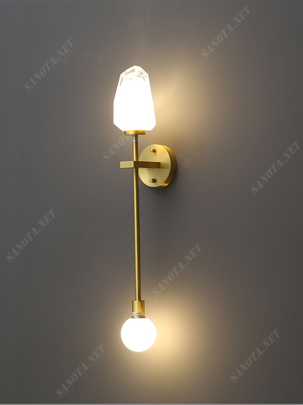 một chiếc đèn gắn tường led với thiết kế hiện đại và độc đáo khi thiết kế một chiếc đèn tối giản là một thanh hợp kim mạ vàng được cố định bởi một đế đèn chắc chắn trên tường, điểm nhấn độc đáo là sự kết hợp của bóng đèn chao thuỷ tinh như một viên đá cẩm thạch, chiếc đèn như một cây quyền trượng đầy độc đáo, khi được bật ánh sáng phát ra từ bóng đèn led tạo một cảm giác ấm áp dịu nhẹ, nhưng vẫn đủ chiếu sáng cho cả một không gian, chiếc đèn sẽ là một món đồ trang trí cho nhiều không gian tăng thêm phần thu hút cho nội thất hiện đại và sang trọng