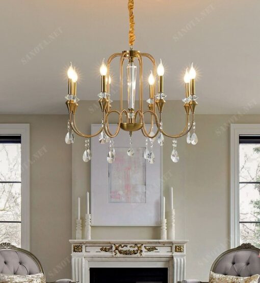 một chiếc đèn chùm sang trọng và hiện đại, nó được thiết theo hơi hướng retro bởi thân đèn làm bằng đồng mạ vàng sáng bóng bền bỉ và chắc chắn, chiếc đèn có thiết kế là một chùm đèn với những cánh tay đèn uốn cong trên mỗi tay đèn là một bóng đèn thuỷ tinh trong suốt như những ngọn nến, ngoài ra chiếc đèn chùm sang trọng còn thêm phần thu hút bởi những dây pha lê trong suốt, khi chiếc đèn được bật một sự kết hợp của màu sắc hài hoà, ấm áp lung linh, nơi nào có chiếc đèn này ở đó chắc chắn sẽ là một không gian lãng mạn và sang trọng, một chiếc đèn vừa là vật trang trí tạo điểm nhấn cho nội thất vừa là vật chiếu sáng cho khắp cả không gian