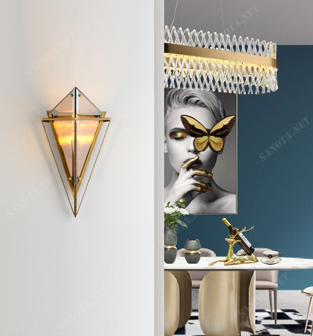 một chiếc đèn gắn tường với thiết kế độc đáo kiểu dáng hình học, thân đèn từ chất liệu hợp kim sơn tĩnh điện chắc chắn và bền bỉ, xung quanh các mặt của chiếc đèn được phủ thuỷ tinh trong suốt, với thiết kế đèn gắn tường hiện đại, chiếc đèn sẽ phù hợp với mọi không gian nội thất, sẽ là món đồ trang trí độc đáo cho bất kì phong cách nào, tôn lên gu thẩm mỹ của chủ nhân căn nhà