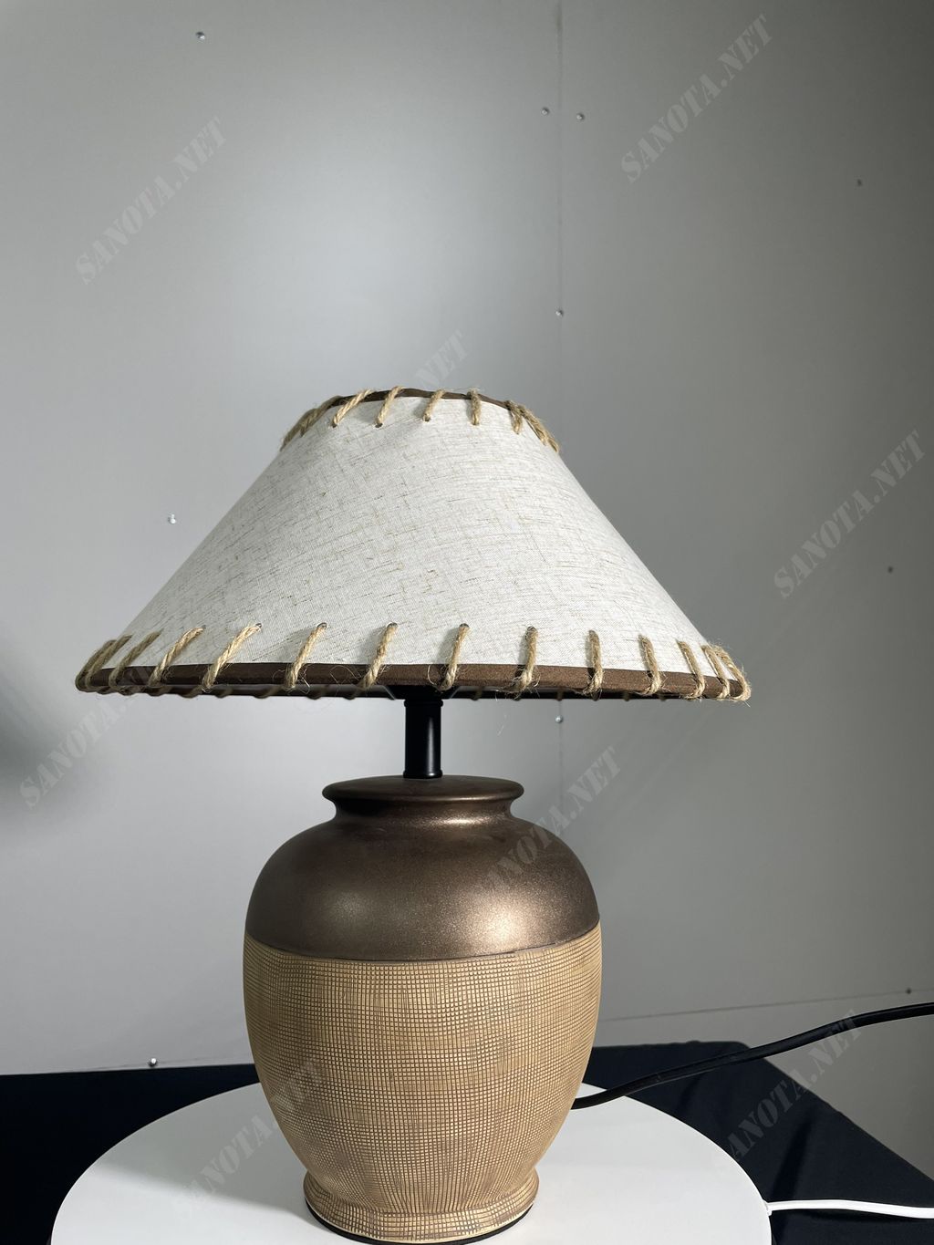 một chiếc đèn bàn với thiết kế độc đáo với thân đèn gốm sứ và chao vải, chiếc đèn bàn là sự kết hợp độc đáo của vẻ đẹp hiện đại và thiên hướng cổ điền trong thiết kế, chiếc đèn vừa là món đồ trang trí vừa là vật thắp sáng không gian ấm áp, đưa đến ánh sáng dịu nhẹ thư giãn, vì vậy mà chiếc đèn sẽ phù hợp đặt ở phòng ngủ, phòng khách hay những không gian thư gian khác nhưng vẫn có thể trang trí, đây chắc chắn sẽ là chiếc đèn mà bạn đang tìm kiếm cho không gian nghỉ ngơi của mình