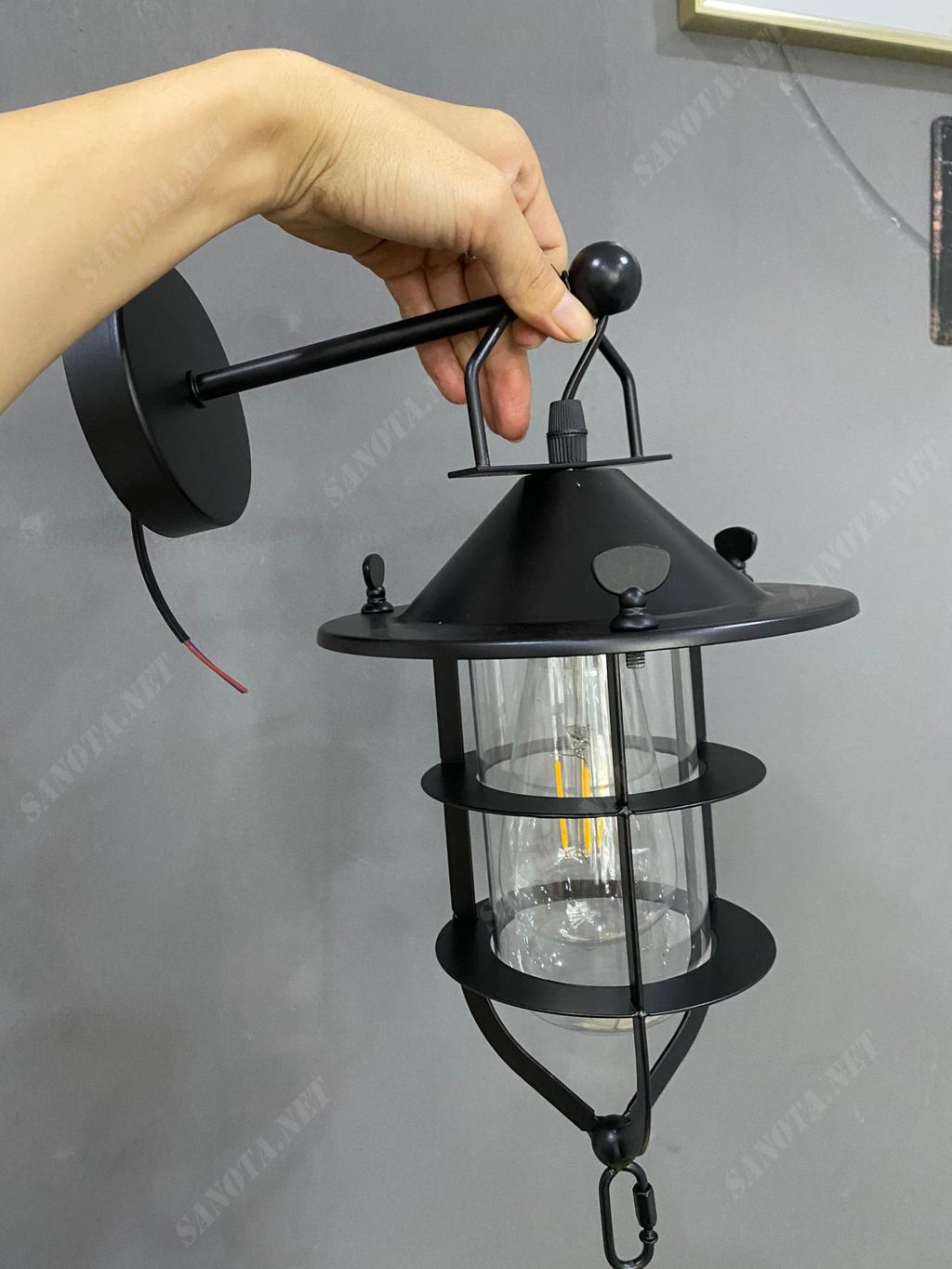 một chiếc đèn gắn tường hiện đại là một chiếc đèn tường thiết kế là chiếc lồng sắt sơn tĩnh điện màu đen một nét đẹp cá tính hiện đại, với chao đèn thuỷ tinh đem đến chất lượng ánh sáng tốt, khi chiếc đèn được bật ánh sáng ấm áp lan toả khắp không gian, với thiết kế của chiếc đèn tường nó phù hợp với mọi không gian, là món đồ trang trí trong nội thất căn nhà của bạn, nó có thể đặt ở phòng khách, phòng ngủ, phòng làm việc, hành lang, hay ngoài sân vườn, ngoài ra còn có thể là món đồ trang trí cho các không ian hành lang hiện đại của khách sạn, resort,...