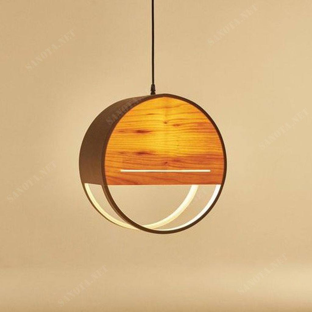 một chiếc đèn thả gỗ với thiết hiện đại và đơn giản là một hộp tròn có chất liệu gỗ tự nhiên, một chiếc đèn được làm thủ công từ gỗ tự nhiên và gỗ công nghiệp đã qua xử lý tinh tế. Chiếc đèn thả này không chỉ thể hiện sự tự nhiên mộc mạc. Mà còn đảm bảo độ bền và độ ổn định của sản phẩm. Tạo ra một sản phẩm vừa độc đáo vừa đẹp mắt. Chiếc đèn gỗ thả trần được ứng dụng phù hợp hầu hết với các không gian trang trí nội thất. Từ phòng khách sang trọng đến nhà bếp hay phòng ngủ cần sự ấm áp thì đều có những chiếc đèn gỗ phù hợp. Không chỉ dùng trang trí trong gia đình, những chiếc đèn gỗ thả trần trang trí còn được sử dụng rất nhiều tại các quán ăn, quán cafe, nhà hàng, khách sạn, resort…