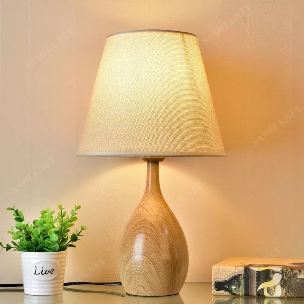 một chiếc đèn để bàn hiện đại với thiết kế đơn giản sử dụng chất liệu thân đèn bằng gỗ và chao vải, chiếc đèn sẽ vừa là chiếc đèn thắp sáng cho không gian sống của bạn vừa là món đồ trang trí tạo nên một điểm nhấn đặc biệt thu hút sự chú ý của mọi người. Không gian nội thất hay ngoại thất là điều bạn lưu tâm nhất trong việc tạo ra không gian sống. Một không gian được bày bố hợp với ý tưởng của bạn là điều tuyệt vời. Sẽ tuyệt vời hơn nếu không gian ấy được màu sắc của ánh sáng chiếu rọi. Chiếc đèn bàn gỗ này sẽ là lựa chọn lý tưởng cho không gian sống năng động tươi trẻ của bạn, phù hợp cho phòng ngủ ấm áp, hay phòng khách sang trọng, cả phòng làm việc hiện đại. Với sự phong phú về kiểu dáng thiết kế, ngôi nhà bạn sẽ thêm xinh đẹp. Với công nghệ chiếu sáng hiện đại, không gian của bạn sẽ bừng sáng nổi bật