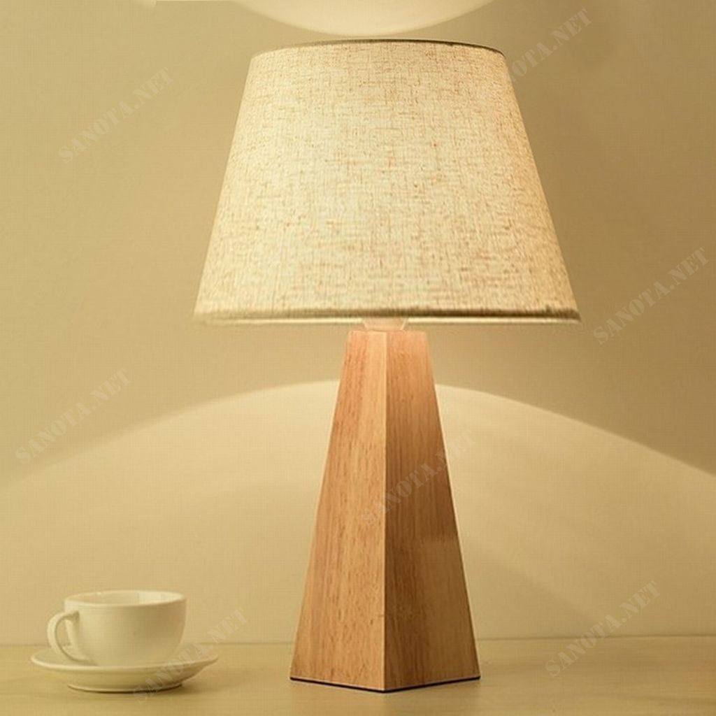 một chiếc đèn để bàn hiện đại với thiết kế đơn giản sử dụng chất liệu thân đèn bằng gỗ và chao vải, chiếc đèn sẽ vừa là chiếc đèn thắp sáng cho không gian sống của bạn vừa là món đồ trang trí tạo nên một điểm nhấn đặc biệt thu hút sự chú ý của mọi người. Không gian nội thất hay ngoại thất là điều bạn lưu tâm nhất trong việc tạo ra không gian sống. Với thiết kế độc đáo thân đèn hình trụ tứ giác kết hợp với chao vải mềm mại. Một không gian được bày bố hợp với ý tưởng của bạn là điều tuyệt vời. Sẽ tuyệt vời hơn nếu không gian ấy được màu sắc của ánh sáng chiếu rọi. Chiếc đèn bàn gỗ này sẽ là lựa chọn lý tưởng cho không gian sống năng động tươi trẻ của bạn, phù hợp cho phòng ngủ ấm áp, hay phòng khách sang trọng, cả phòng làm việc hiện đại. Với sự phong phú về kiểu dáng thiết kế, ngôi nhà bạn sẽ thêm xinh đẹp. Với công nghệ chiếu sáng hiện đại, không gian của bạn sẽ bừng sáng nổi bật