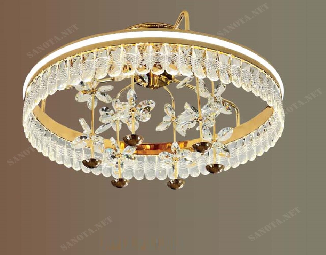 Một chiếc đèn chùm với thiết kế sang trọng và thanh lịch, chiếc đèn chùm này sẽ mang đến cho ngôi nhà bạn vẻ đẹp lộng lẫy và đẳng cấp. Khung đèn được làm từ kim loại cao cấp, mạ vàng sáng bóng, kết hợp với những viên pha lê trắng tinh khiết cùng với điểm nhấn là nhuungwx bông hoa pha lê bốn cánh, tạo nên một tổng thể hài hòa và thu hút mọi ánh nhìn. Đèn chùm những cánh hoa pha lê tinh tế sở hữu thiết kế độc đáo với những chi tiết uốn lượn mềm mại, tinh tế. Những cánh hoa được sắp xếp theo hình vòng tròn, tạo nên hiệu ứng ánh sáng lung linh huyền ảo khi đèn được bật sáng. Chiếc đèn phù hợp để sử dụng cho nhiều không gian khác nhau như phòng khách, phòng ngủ, phòng ăn, sảnh nhà hàng, khách sạn… Ánh sáng dịu nhẹ của đèn sẽ mang đến cho bạn cảm giác thư giãn và thoải mái.