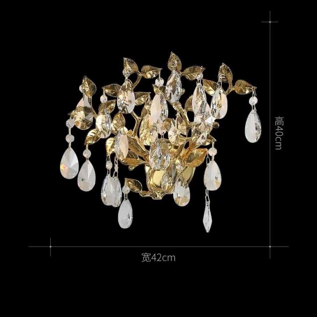 Đèn tường hoa pha lê được chế tác với khung mạ vàng ánh kim nổi bật, uốn lượn thành từng nhánh lá mềm mại. Kết hợp khéo léo cùng pha lê cao cấp cắt giác hoàn hảo. Ánh sáng lan tỏa nhẹ nhàng phản chiếu qua từng giọt pha lê. Tạo nên hiệu ứng lung linh, quyến rũ, đầy thu hút. Kiểu dáng đèn như một nhành cây vàng óng ánh đơm hoa kết trái. Mang ý nghĩa phồn vinh và thịnh vượng cho gia chủ.