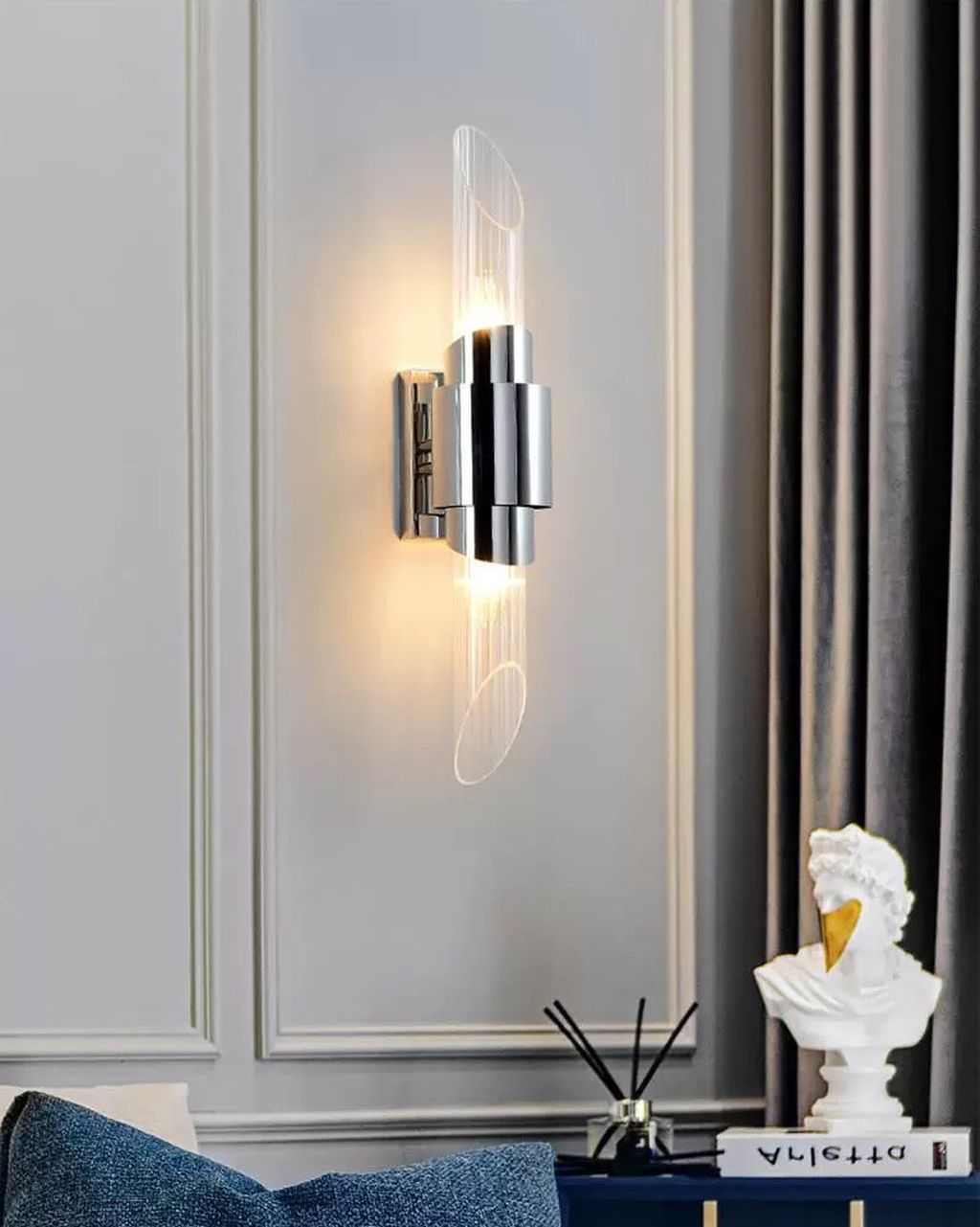 Với thiết kế dạng ống đôi độc đáo kết hợp chất liệu inox sáng bóng và kính trong suốt, đèn mang lại vẻ đẹp tối giản nhưng đầy quyến rũ. Hiệu ứng ánh sáng phát ra từ hai đầu đối xứng giúp không gian trở nên ấm cúng, sang trọng mà không kém phần hiện đại.