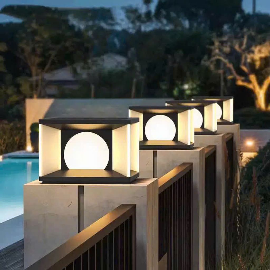 Đèn trụ cổng hiện đại với thiết kế hình hộp vuông vức kết hợp cùng ánh sáng mềm mại từ quả cầu tròn tinh tế. Đèn tạo nên hiệu ứng ánh sáng lan tỏa dịu nhẹ nhưng vẫn đủ nổi bật vào ban đêm. Được lắp đặt dọc theo hàng rào hoặc lối đi sân vườn. Chiếc đèn không chỉ giúp chiếu sáng lối đi mà còn nâng tầm giá trị thẩm mỹ cho toàn bộ kiến trúc ngôi nhà.