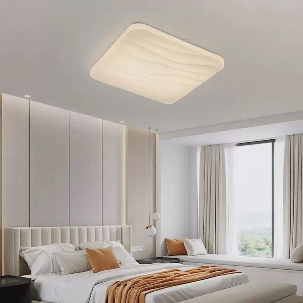 Mâm đèn ốp trần lấy cảm hứng từ những đường nét uyển chuyển, sở hữu thiết kế dạng vuông bo góc mềm mại. Bề mặt được tạo gợn nhẹ nhàng như sóng nước. Mang đến cảm giác thư thái, gần gũi nhưng không kém phần hiện đại. Tông màu trắng ngà chủ đạo giúp đèn dễ dàng kết hợp với mọi phong cách nội thất từ tối giản, hiện đại cho đến Scandinavian.