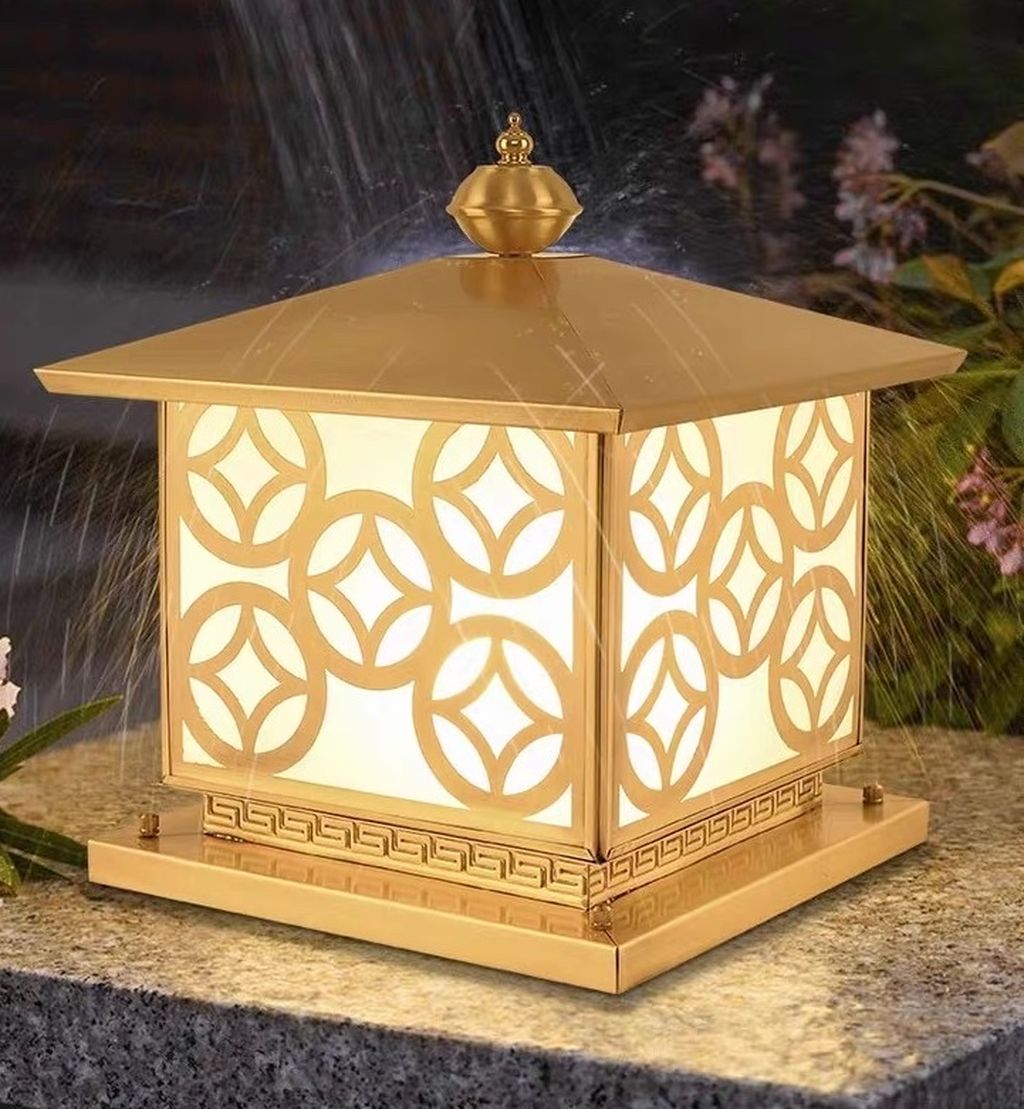 Đèn trụ cổng mạ vàng sang trọng SNT5586 với thiết kế lấy cảm hứng từ phong cách Á Đông hiện đại. Chiếc đèn nổi bật nhờ hoa văn hình học đồng tâm được cắt CNC tỉ mỉ, sắc nét. Ánh sáng bên trong lan tỏa dịu dàng qua lớp kính mờ, không chói lóa mà vẫn đủ sáng, tạo cảm giác ấm cúng và thân thiện ngay từ cái nhìn đầu tiên.