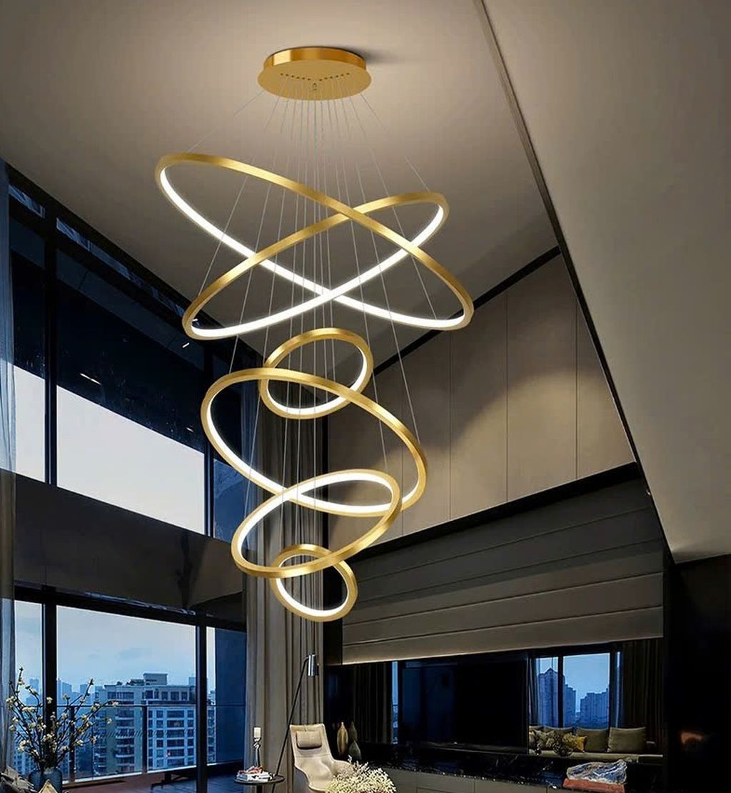 Chiếc đèn thông tầng Led này gây ấn tượng mạnh mẽ với thiết kế xoắn ốc độc đáo. Gồm các vòng kim loại mạ vàng sang trọng kết hợp cùng viền LED ánh sáng trắng dịu nhẹ. Những đường cong mềm mại được sắp xếp đầy nghệ thuật, như một vũ điệu ánh sáng treo lơ lửng giữa không trung, tạo nên hiệu ứng thị giác cuốn hút và đầy mê hoặc.