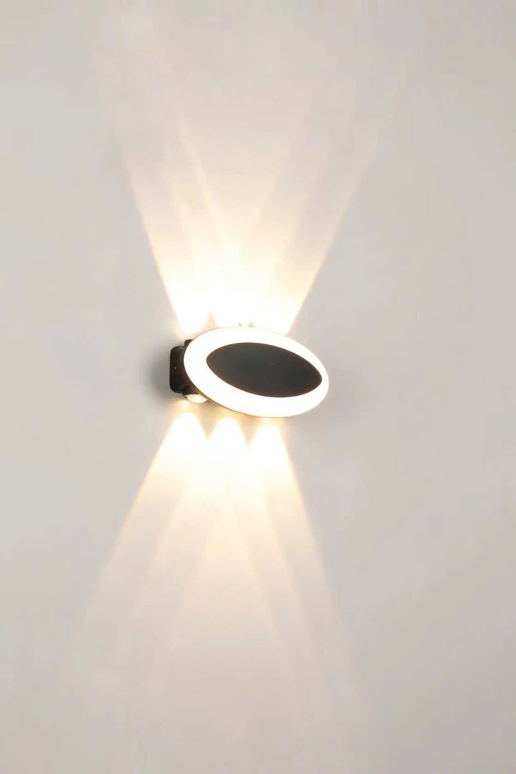 Chiếc đèn hắt tường trang trí này là một biểu tượng của sự hiện đại và sang trọng trong không gian nội thất. Thiết kế của nó được lấy cảm hứng từ hình dáng ova được phối màu đen hiện đại. Tạo nên một vẻ ngoài đầy tinh tế và độc đáo. Với sự tối giản mà không kém phần ấn tượng. Khi chiếc đèn hắt tường ngoài trời được bật, ánh sáng mềm mại được hắt lên từ hai đầu của đèn. Tạo ra một hiệu ứng ánh sáng đặc biệt trên bề mặt tường.