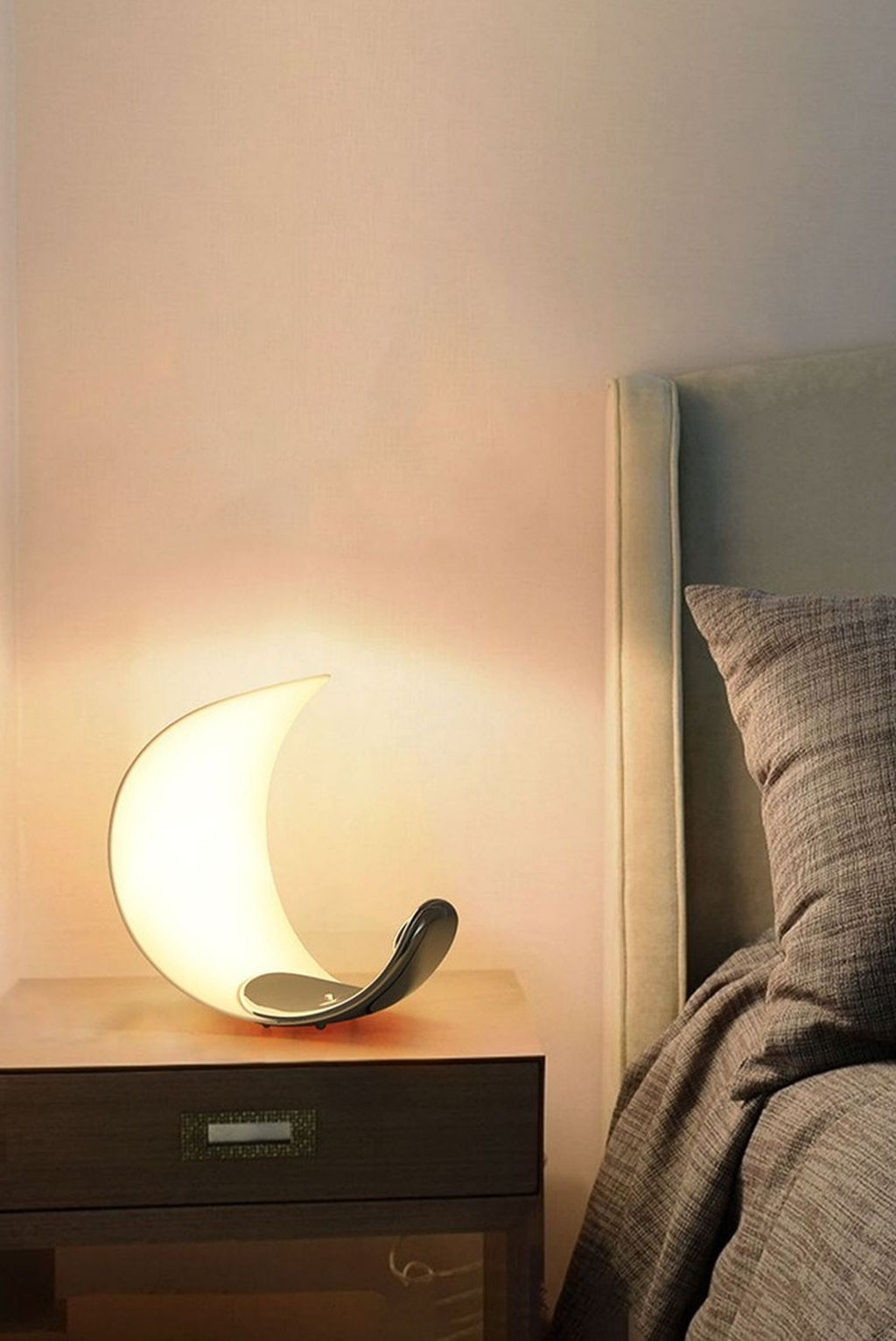 Đèn bàn phòng ngủ gây ấn tượng mạnh ngay từ cái nhìn đầu tiên với thiết kế hình lưỡi liềm uốn cong mềm mại. Mô phỏng hình ảnh vầng trăng đang tỏa sáng. Thân đèn sử dụng chất liệu nhựa cao cấp phủ mờ, giúp ánh sáng lan tỏa dịu nhẹ, không gây chói mắt. Rất thích hợp cho không gian phòng ngủ, nơi bạn cần sự thư giãn, nhẹ nhàng sau một ngày dài làm việc.