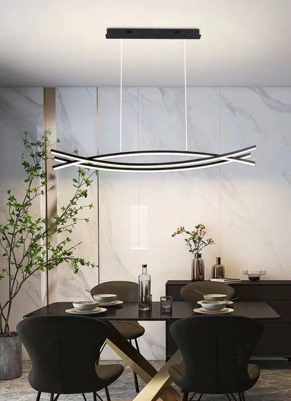 Đèn chùm trang trí lấy cảm hứng từ những đường cong mềm mại kết hợp cùng cấu trúc giao thoa cân xứng. Đèn chùm này nổi bật với hệ khung đèn dạng thanh uốn lượn thanh thoát. Hòa quyện giữa ánh sáng trắng tinh khôi và chất liệu kim loại phủ đen nhám thời thượng. Cấu trúc treo từ trần tối giản giúp đèn trở thành một điểm nhấn thị giác lý tưởng cho phòng ăn, phòng khách hay khu vực tiếp khách sang trọng.