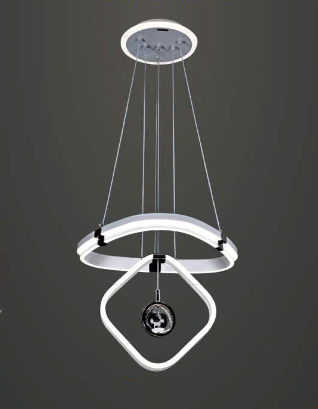 Đèn chùm trang trí không gian gây ấn tượng mạnh với thiết kế hình khối không gian độc đáo. Kết hợp hài hòa giữa các đường cong mềm mại và hình học cân đối. Cấu trúc ba tầng nổi bật với vòng LED ánh sáng trắng mát uốn cong mềm mại. Tạo hiệu ứng thị giác mạnh mẽ nhưng không hề rối mắt. Trung tâm đèn là quả cầu pha lê đen ánh kim được treo tinh tế giữa khung vuông bo tròn, mang lại cảm giác cân bằng và thanh thoát.