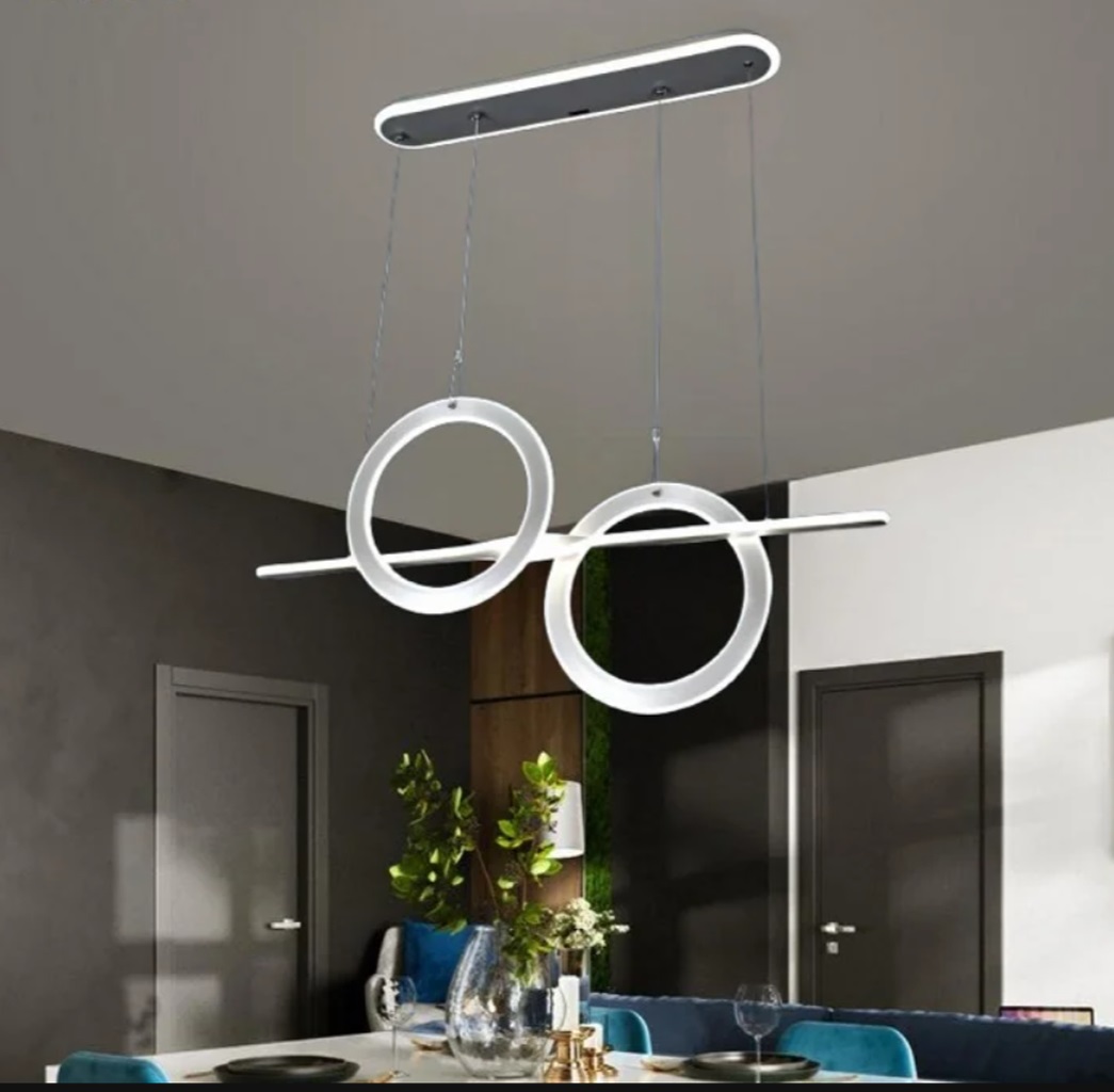 Đèn chùm vòng tròn treo trần được thiết kế với hai vòng LED đối xứng. Kết hợp cùng thanh ngang tinh gọn tạo nên bố cục cân đối và hiện đại. Tông màu trắng tinh tế cùng ánh sáng LED dịu nhẹ không chỉ giúp không gian bàn ăn trở nên ấm cúng. Mà còn mang đến cảm giác sang trọng, hiện đại cho toàn bộ căn phòng.