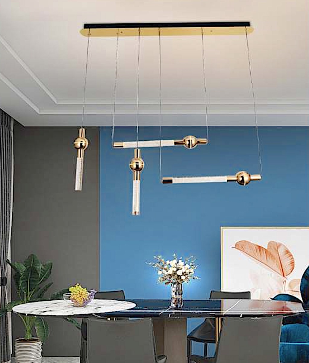 Đèn chùm những thanh đèn mạ vàng được thiết kế theo phong cách tối giản nhưng đầy nghệ thuật. Đèn sử dụng các thanh đèn thẳng mảnh, được bố trí bất đối xứng nhưng đầy chủ đích, tạo nên một tổng thể hài hòa và thu hút ánh nhìn. Những chi tiết mạ vàng sáng bóng góp phần tôn vinh sự cao cấp, tinh tế.