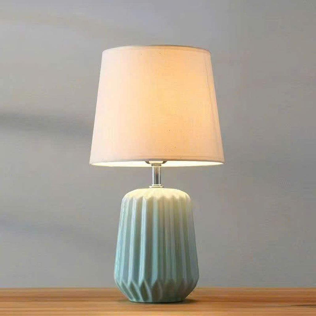 Đèn bàn gốm sứ với vẻ đẹp dịu dàng, thiết kế độc đáo. Thân đèn được làm từ chất liệu gốm sứ, tinh tế và mềm mại dưới bàn tay của nghệ nhân. Chao đèn bằng vải mềm mại, mang đến cảm giác êm ái và ấm áp khi ánh sáng từ bên trong lan tỏa ra ngoài. Sự kết hợp của gốm sứ và vải tạo nên một cảm giác hài hòa, tinh tế, và đặc biệt là độc đáo.