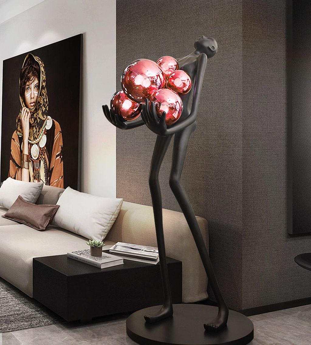 Đèn đứng trang trí nghệ thuật này được chế tác với hình dáng một người phụ nữ thanh mảnh, mang phong thái tự tin và kiêu hãnh. Tay nâng nhẹ một quả cầu ánh sáng tượng trưng cho ánh trăng dịu dàng. Chất liệu nhựa composite cao cấp phủ lớp sơn đen lì sang trọng. Tạo hiệu ứng thị giác mạnh mẽ và đậm chất nghệ thuật hiện đại. Với thiết kế đèn sàn đứng cao và thanh thoát, sản phẩm này không chỉ phù hợp với các không gian phòng khách, phòng ngủ cao cấp. Mà còn lý tưởng để đặt tại tiền sảnh, hành lang hay khu vực trưng bày nghệ thuật.