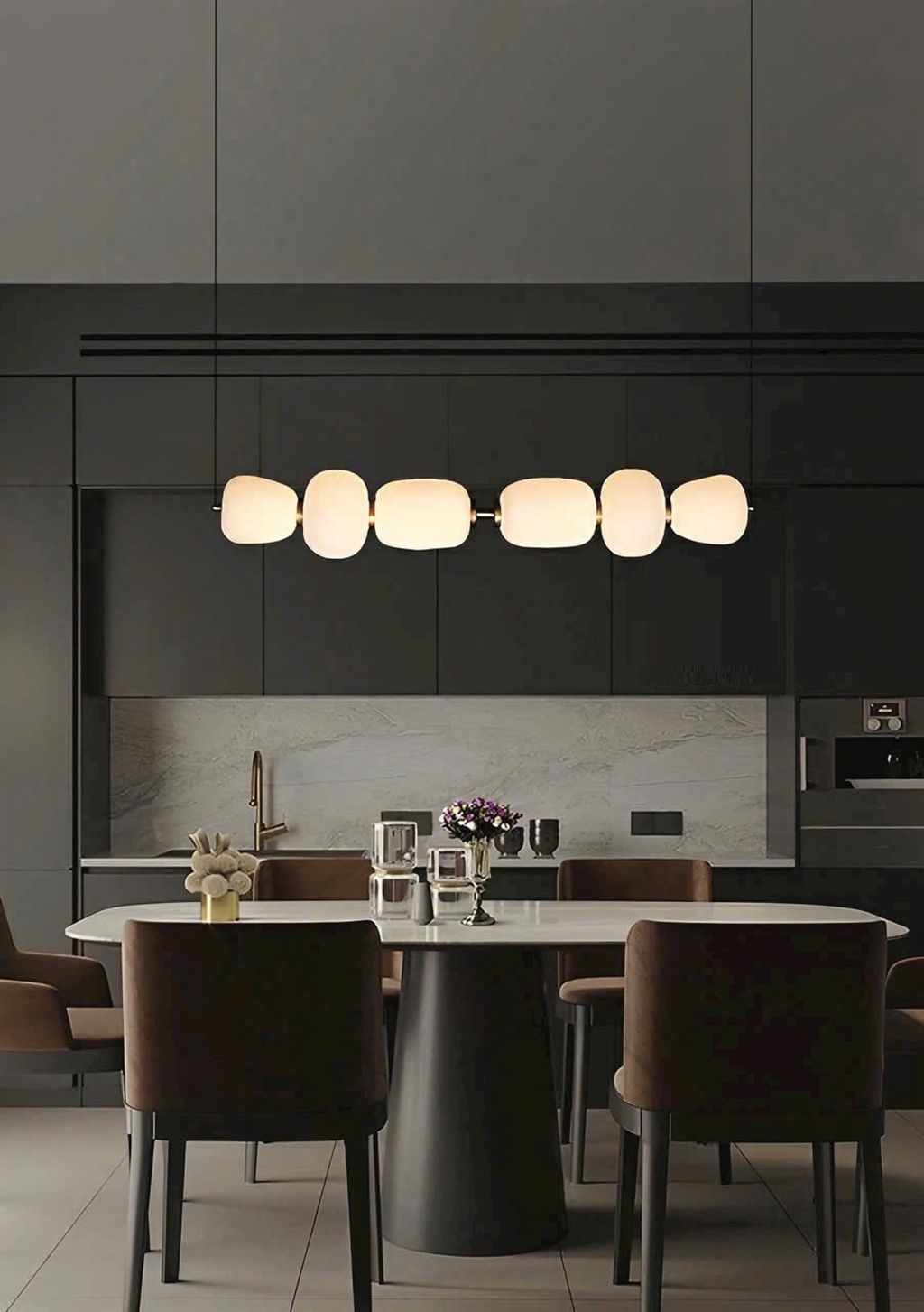 Đèn chùm chao thuỷ tinh sang trọng với thiết kế đèn chùm được lấy cảm hứng từ phong cách tối giản Á Đông. Với thân đèn kim loại mạ đồng ánh vàng sang trọng, kết nối khéo léo với từng chao đèn thủy tinh mờ có hình dáng độc đáo. Những đường cong mềm mại xen kẽ theo nhịp điệu tạo cảm giác nhịp nhàng như một chuỗi ngọc tinh xảo treo lơ lửng giữa không trung.