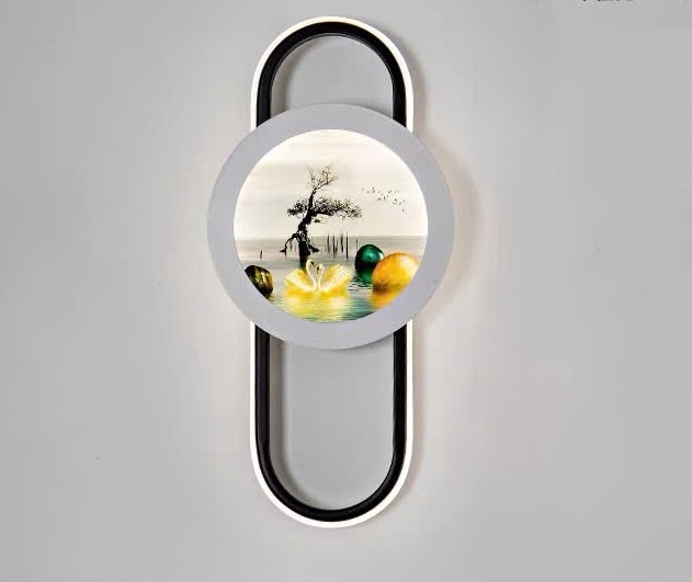 Đèn tường phong cảnh thiên nga gây ấn tượng với thiết kế khung oval hiện đại. Kết hợp mặt tròn trung tâm in hình thiên nga, hồ nước và cây cổ thụ đầy tính nghệ thuật. Sự hòa quyện giữa ánh sáng LED dịu nhẹ và hình ảnh thiên nhiên mang đến cảm giác thư thái, bình yên cho không gian.