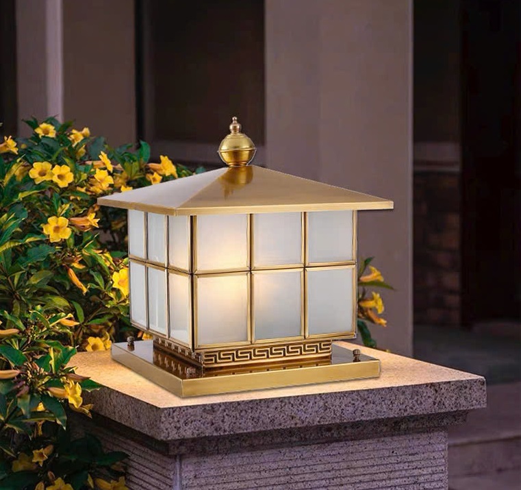 Đèn trụ cổng sân vườn mạ vàng hoa văn ô vuông không chỉ là vật dụng chiếu sáng mà còn là chi tiết trang trí ngoại thất tinh tế. Ban ngày, đèn như một điểm nhấn kiến trúc sang trọng. Ban đêm, ánh sáng vàng lan tỏa đem đến sự an yên và thu hút.