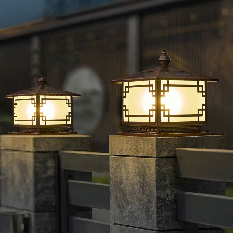 Đèn trụ cổng trang trí sở hữu kiểu dáng vuông vắn, chắc chắn với những hoa văn hình học khỏe khoắn. Họa tiết viền cổ điển tạo điểm nhấn nghệ thuật, gợi cảm giác vừa hiện đại, vừa truyền thống. Khi ánh sáng phát ra từ lớp kính mờ, không gian trở nên ấm áp, trang nhã và đầy cuốn hút.