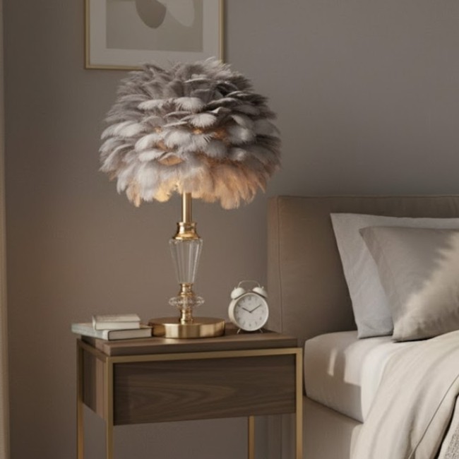 Điểm đặc biệt của chiếc đèn để bàn nghệ thuật này nằm ở phần chao đèn được thiết kế độc đáo từ những lớp lông mềm mịn. Xếp tầng tinh tế như những đám mây bồng bềnh. Khi ánh sáng được bật lên, từng sợi lông phản chiếu ánh vàng nhẹ, tạo nên không gian lung linh và ấm áp. Một cảm giác thư giãn tuyệt đối sau ngày dài làm việc.